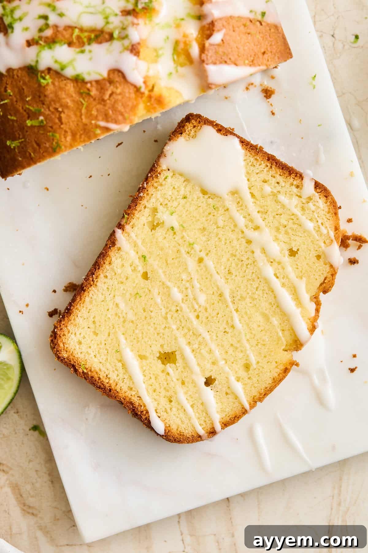 A slice of lime bread with lime glaze drizzled on top.