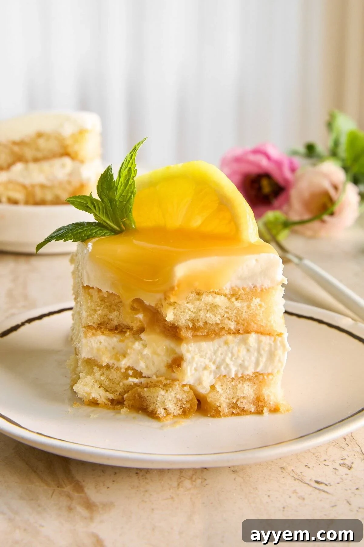 A partially eaten slice of lemon tiramisu on a plate, showing the creamy layers and lemon curd topping, ready for enjoyment.