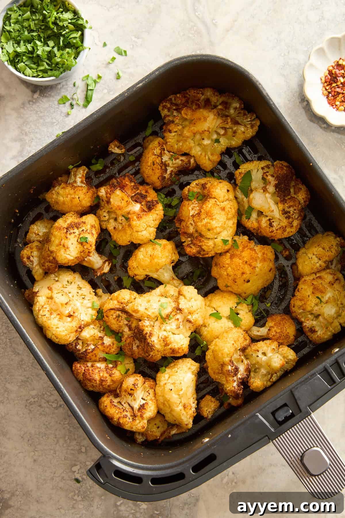 Roasted air fryer cauliflower in an air fryer basket.