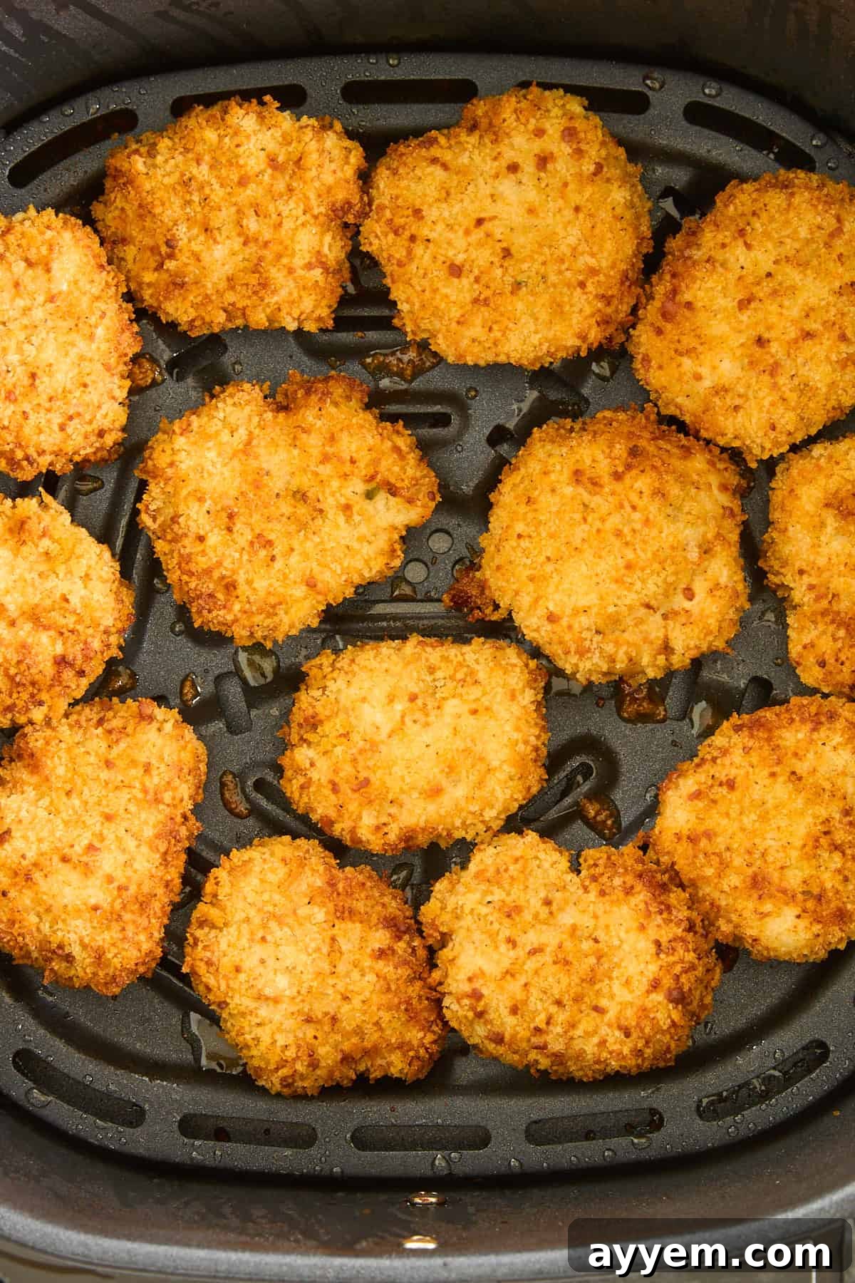 Perfectly cooked, golden-brown chicken nuggets in an air fryer basket, ready to be served.