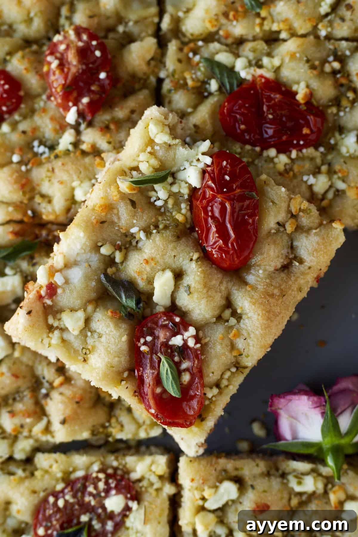 A sheet pan of focaccia bread adorned with fresh herbs and tomatoes, an easy and flavorful side for any Ramadan meal.