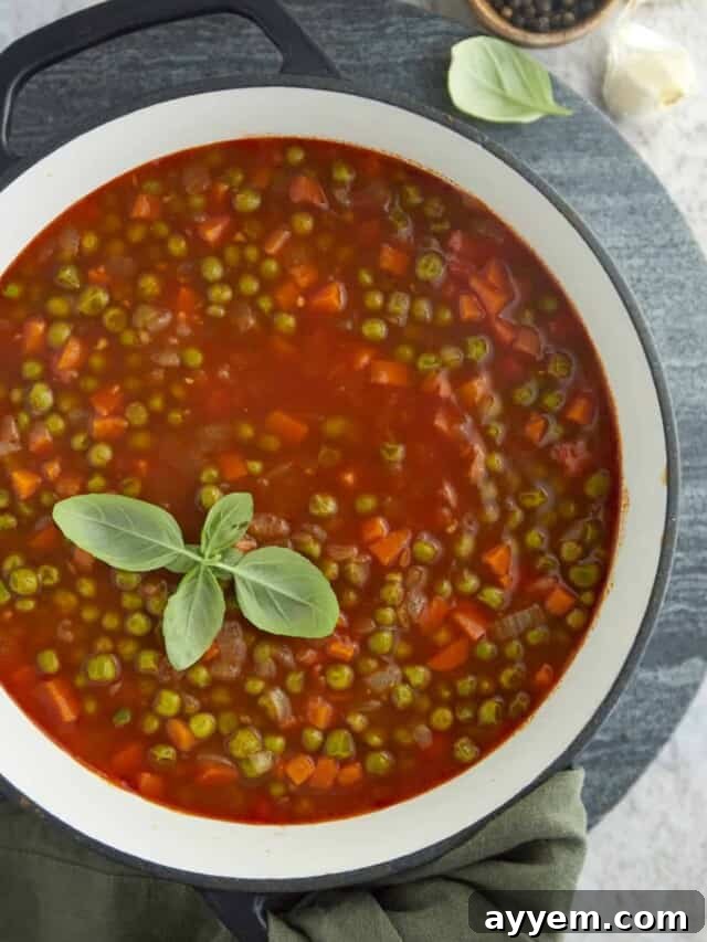 A large pot filled with vibrant pea and carrot vegetarian stew, topped with fresh herbs, a wholesome and budget-friendly Iftar meal.