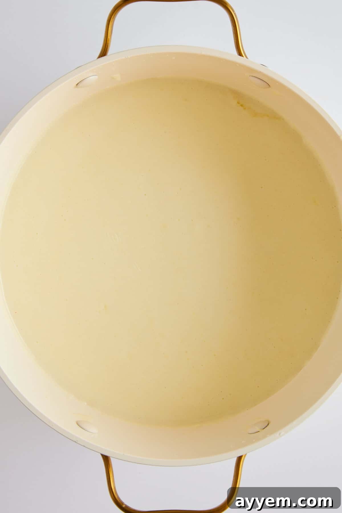 A pot of beautifully smooth, white béchamel sauce.