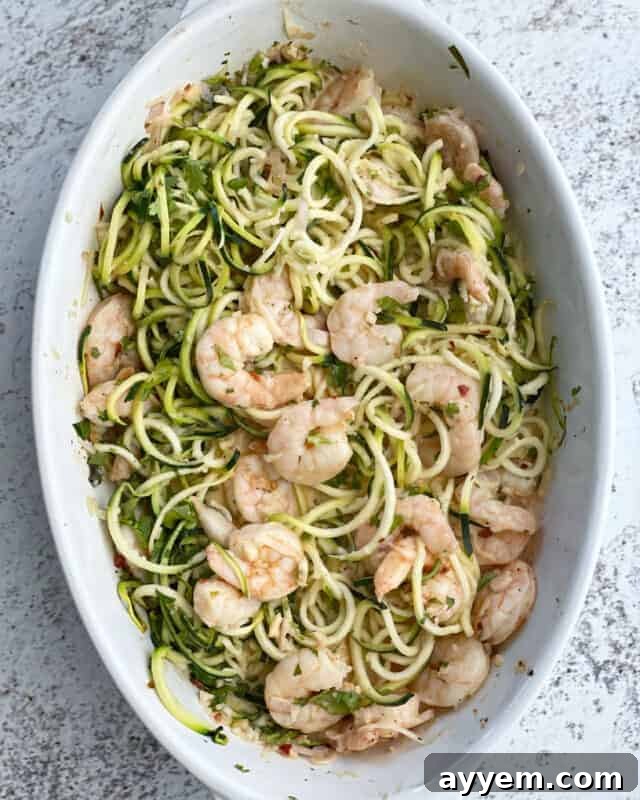 healthy shrimp scampi with zucchini noodles in a white oval baking dish